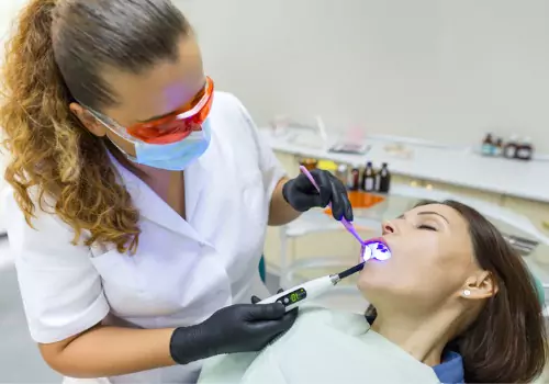 Dentist working in a patients mouth who has taken sedation medication, as part of Sedation Dentistry in Galesburg IL