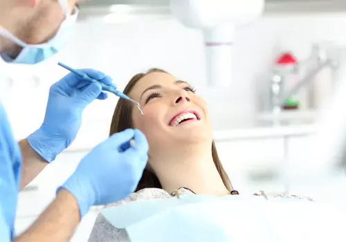 A smiling woman having her teeth cleaned by a dentist, during Sedation Dentistry in Lincoln IL