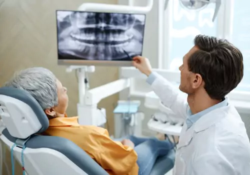 Dentist showing x-ray of teeth to a patient in a Dental Office in Pekin IL