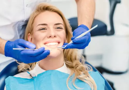 A woman smiles during a dental visit. Total Dental Care offers Teeth Whitening in Peoria IL.